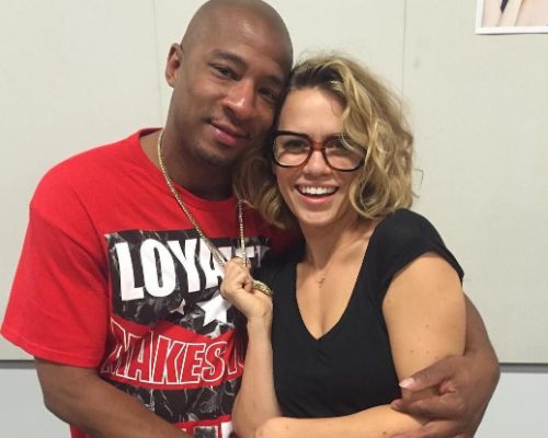 Antwon Tanner posing with his wife by wearing a red T-shirt.